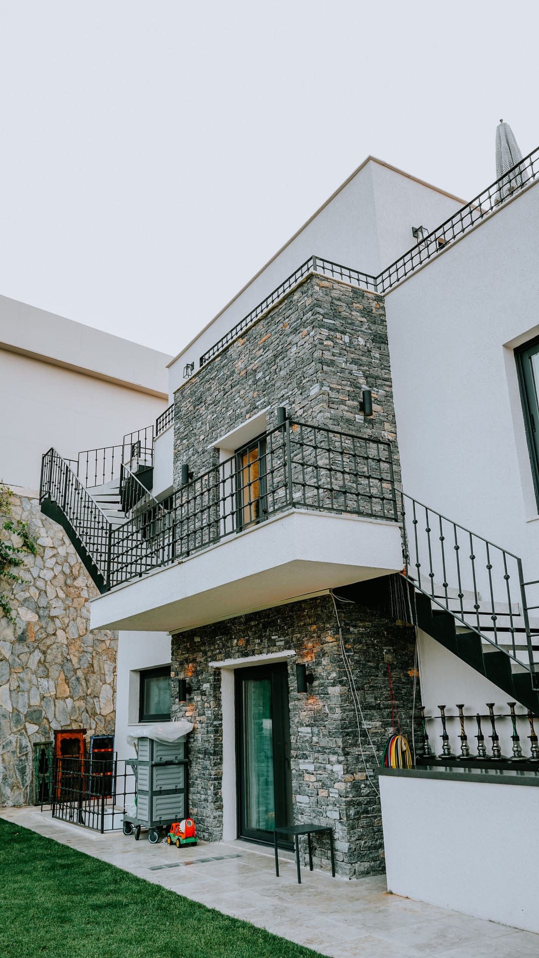 Projects Renovated two-storey building facade with natural stone cladding and wrought iron railings in Alanya
