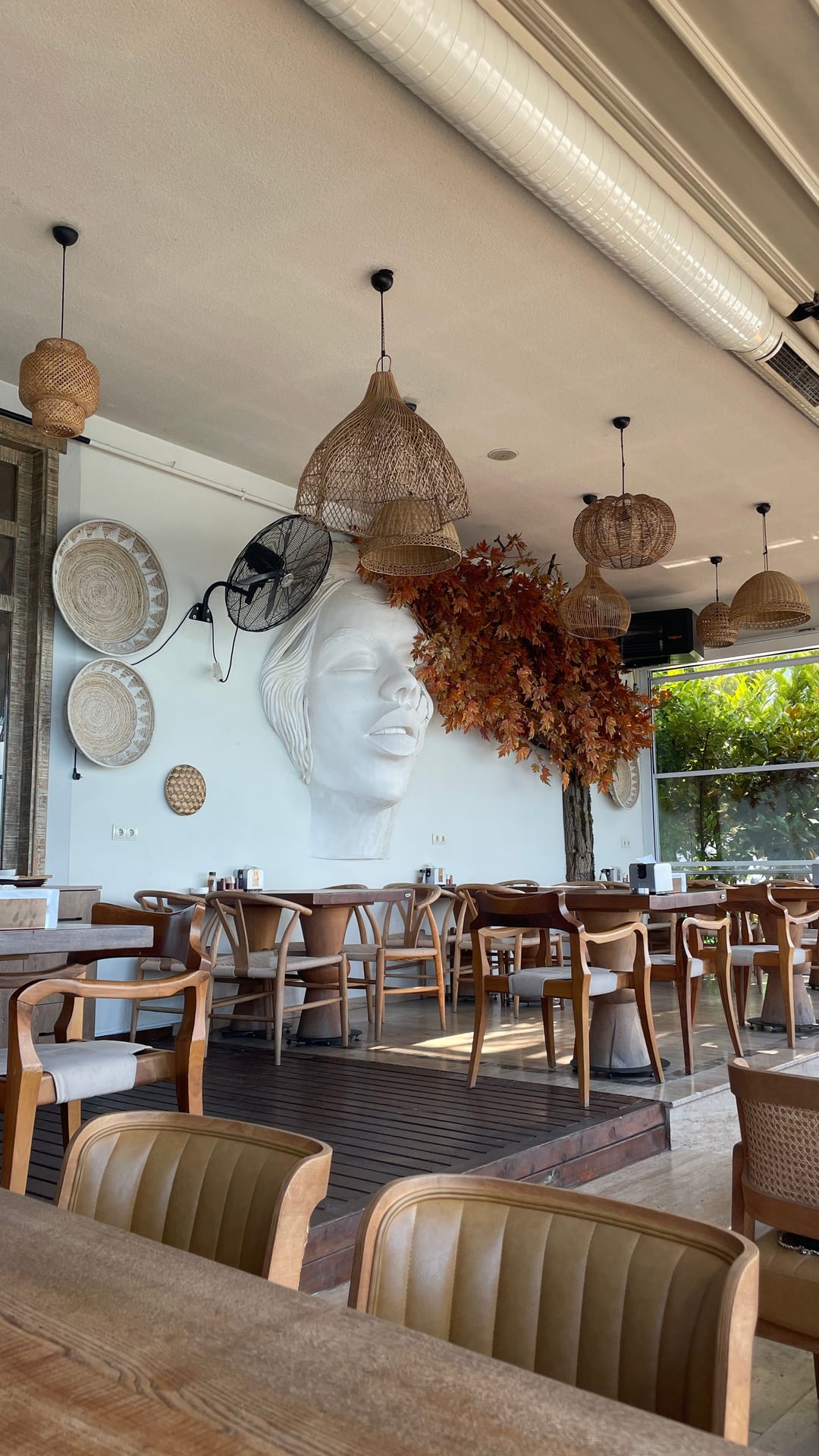Projects Renovated restaurant interior with rattan pendant lights and a sculptural wall detail in Alanya