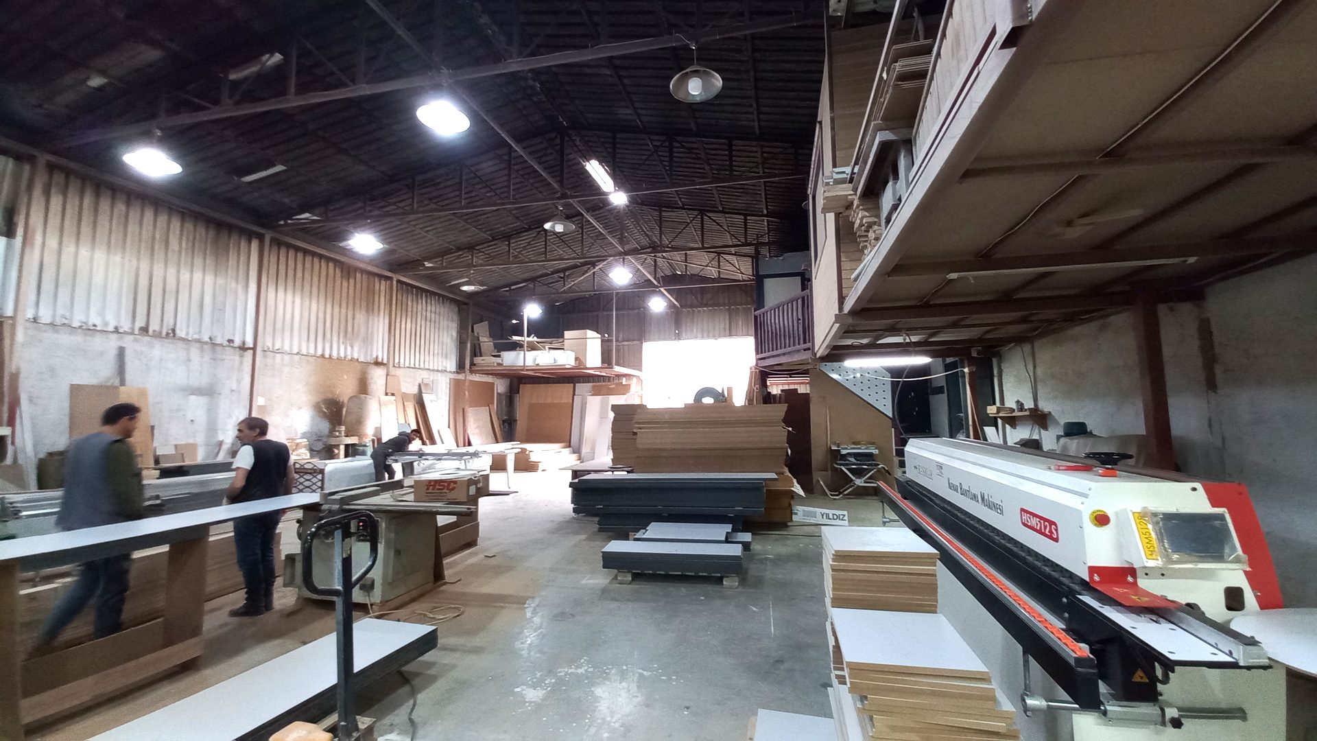 ReFix furniture workshop in Alanya with panel stock, workbenches and an edge banding machine